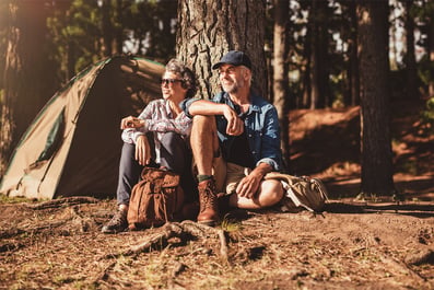 Man and woman sitting in front of a tent while camping