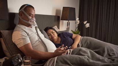 Man in bed with partner using CPAP Therapy
